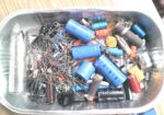Box of assorted capacitors/resistors/cables etc. –